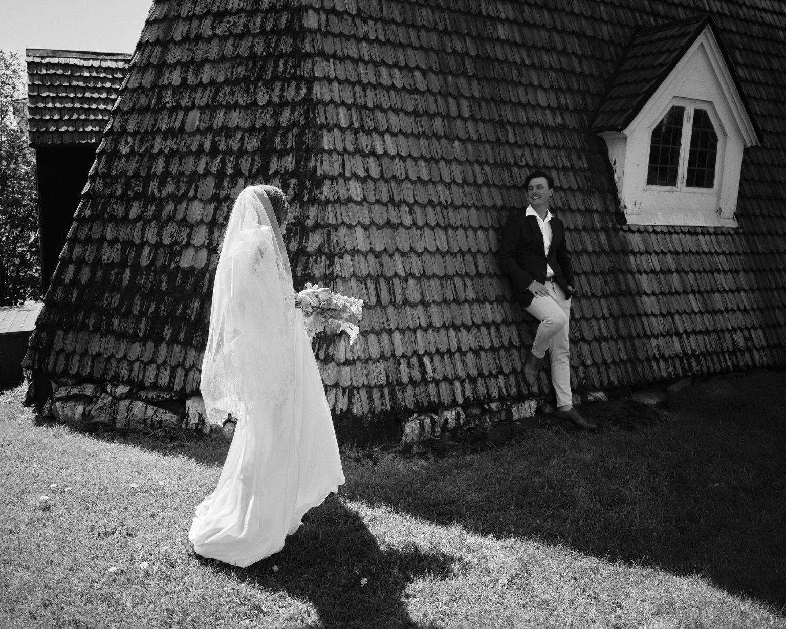 Bride walking past a shingled wooden chapel in Söderhamn