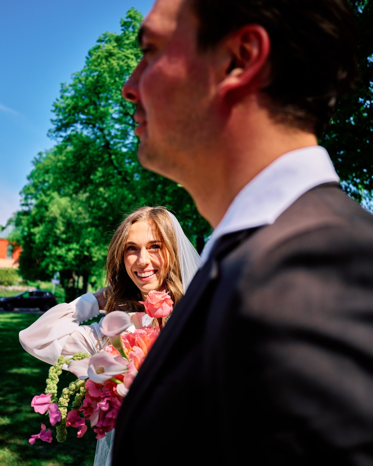Bride with a coral bouquet beside the groom in Söderhamn, Sweden