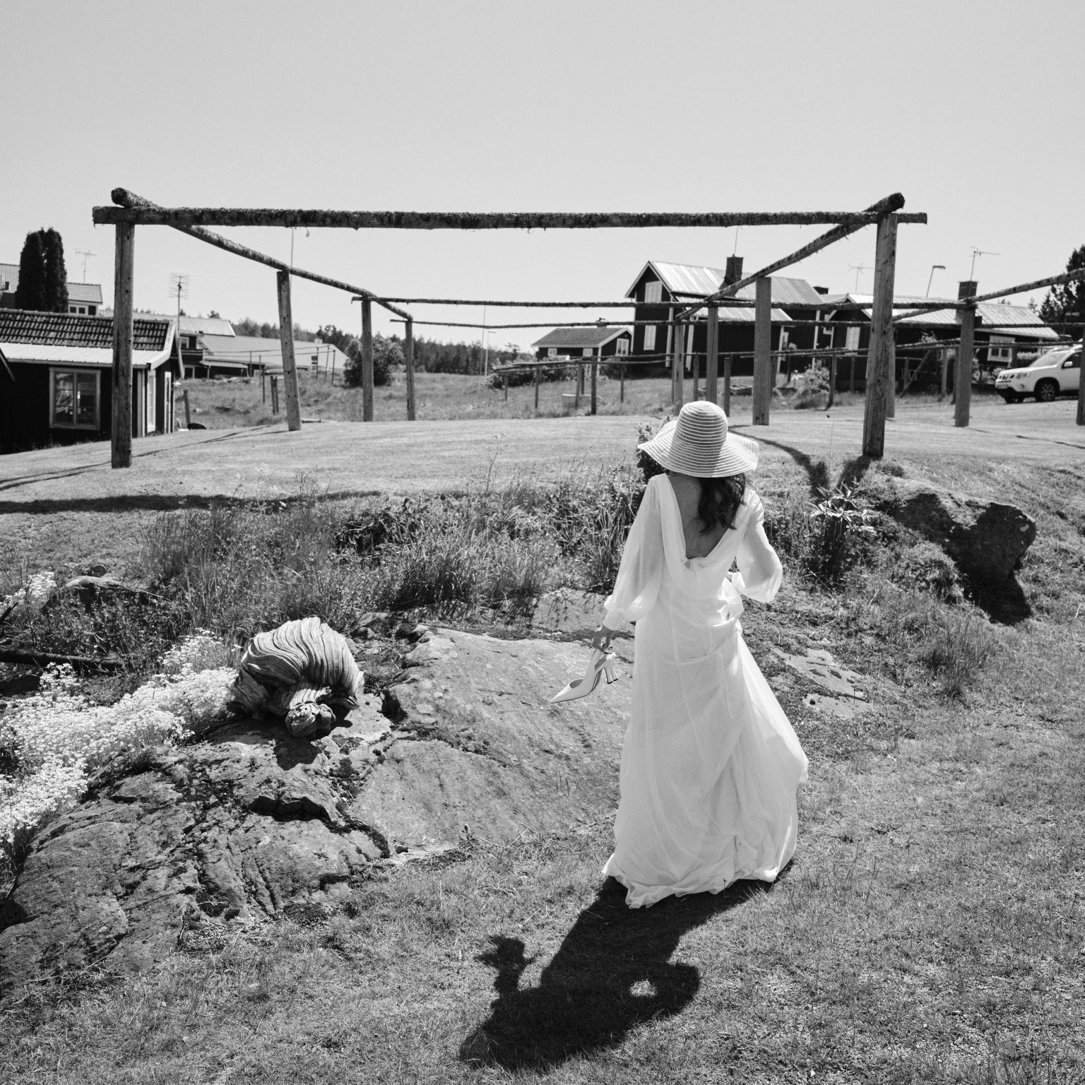 Elin in a wide-brimmed hat walking the rocks at Skärså