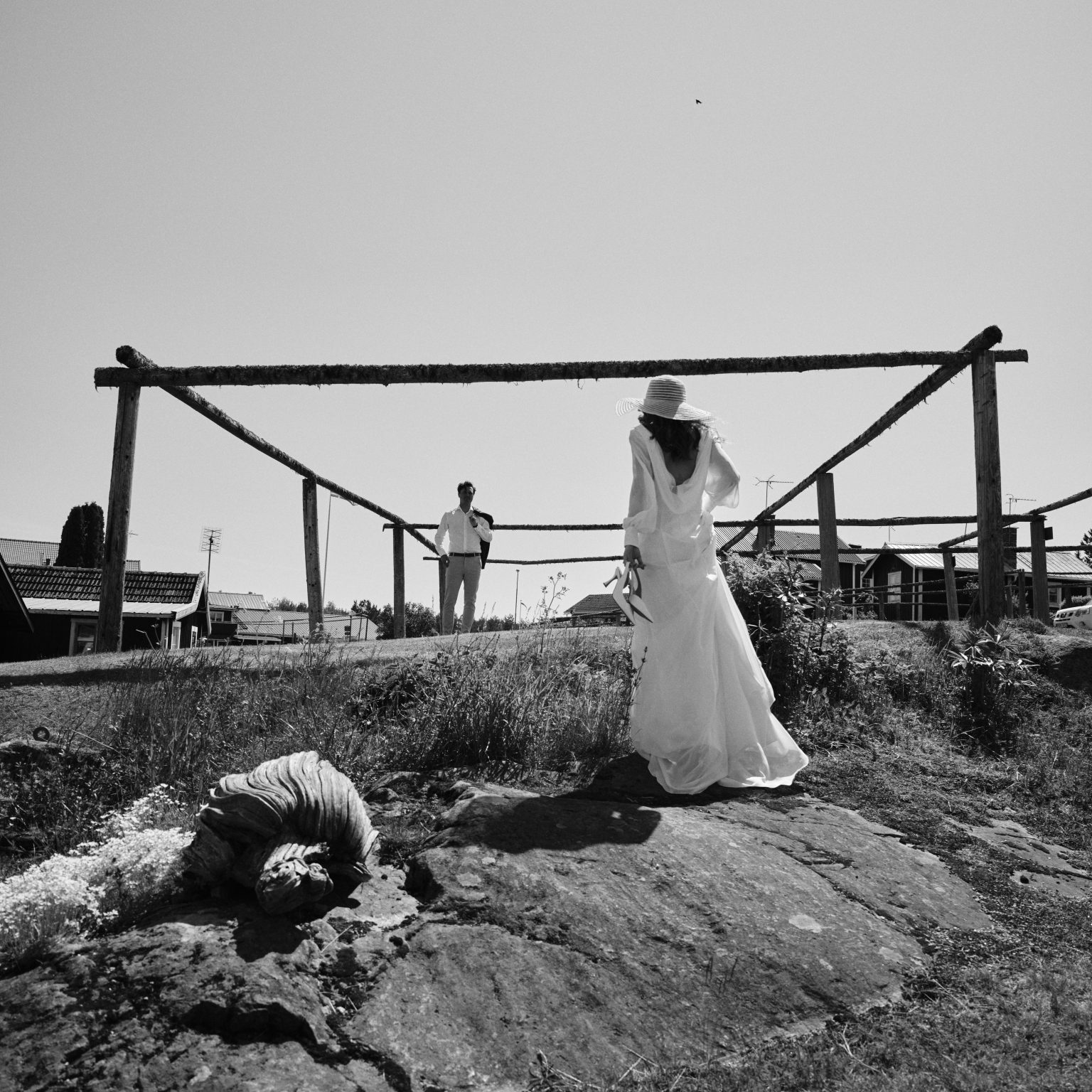 Bride on the harbour rocks at Skärså, groom behind