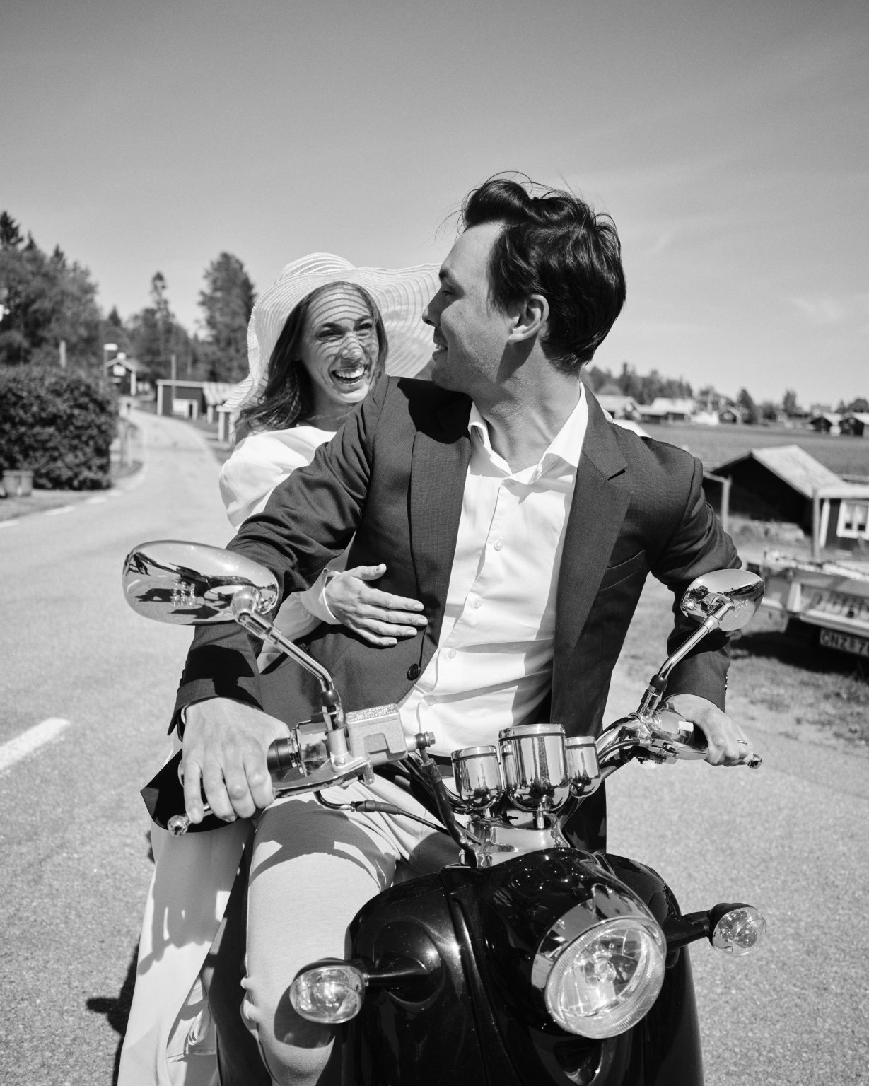 Elin in her hat and Joakim on the moped, Söderhamn coast elopement
