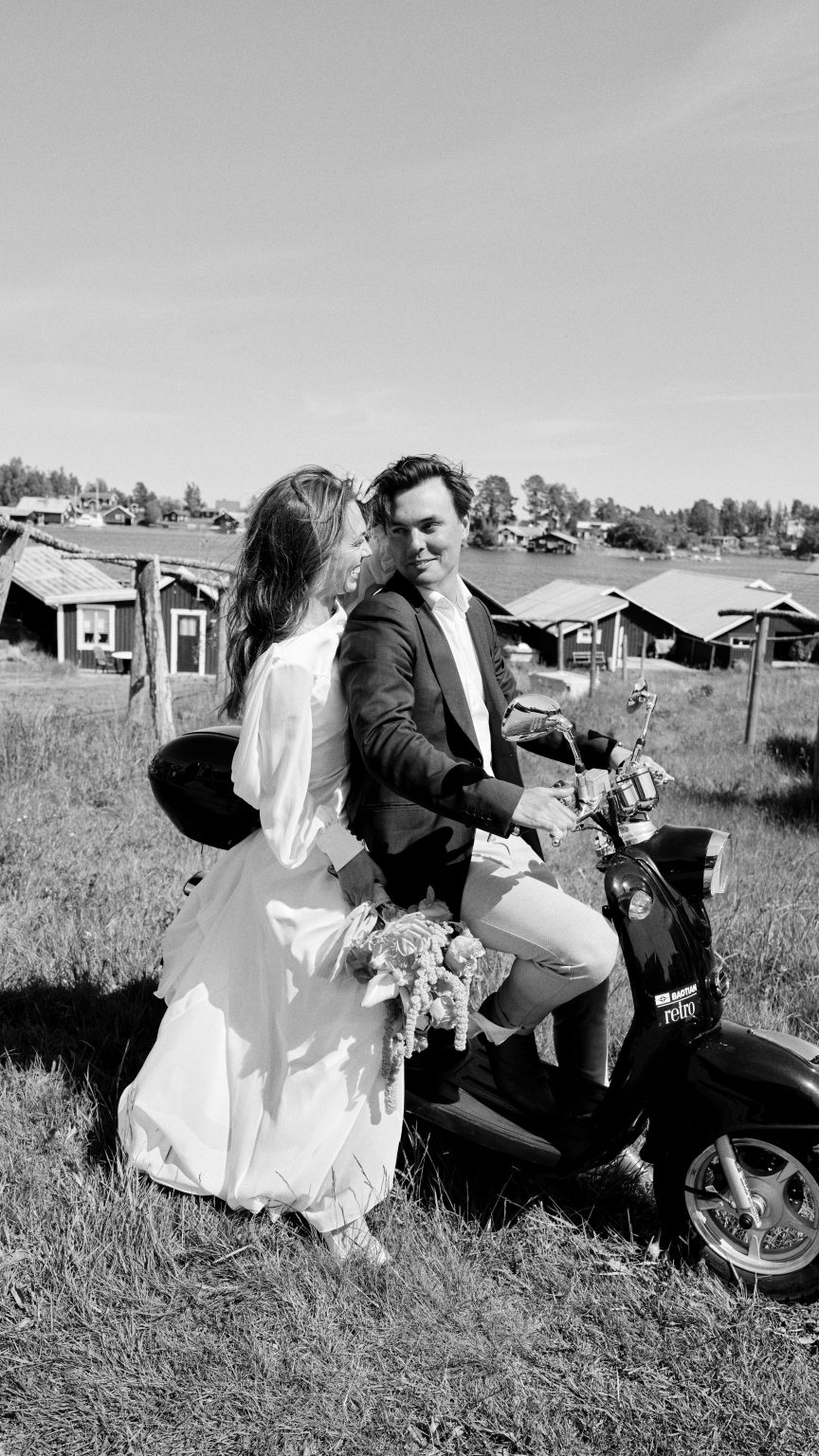 Elin and Joakim on the moped in a meadow on the Söderhamn coast