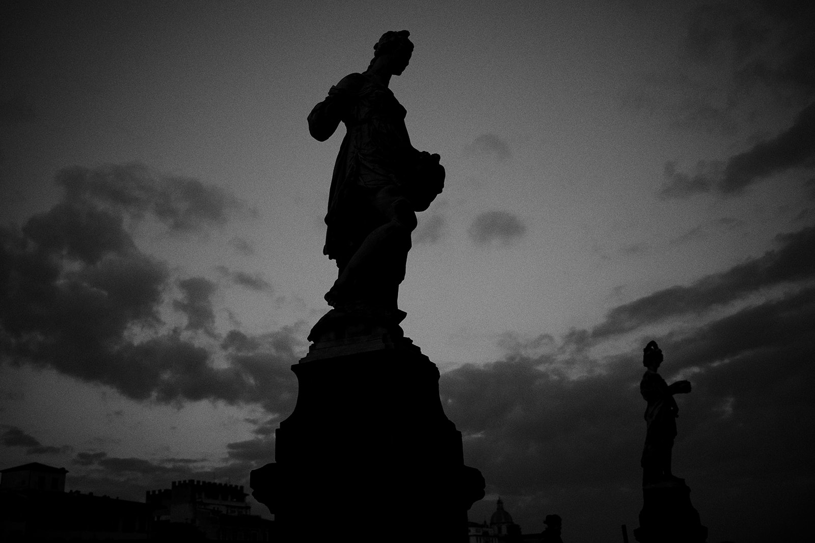 Statue silhouetted against the dawn sky at Piazzale Michelangelo in Florence