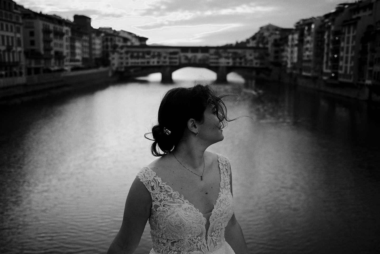 Bride looking back with the Ponte Vecchio behind in Florence