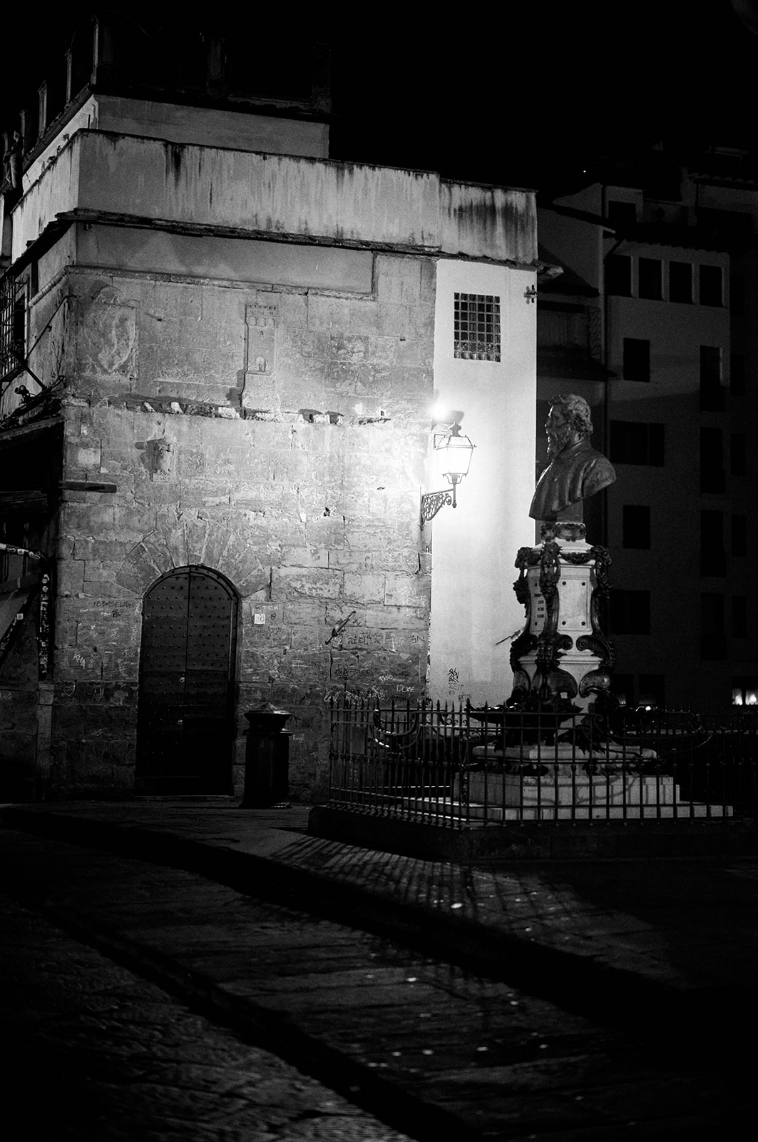 Bride and groom beside a stone column in Florence before dawn