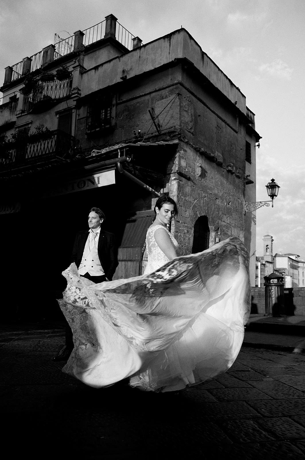 Bride's dress in motion beneath a lamp in Florence
