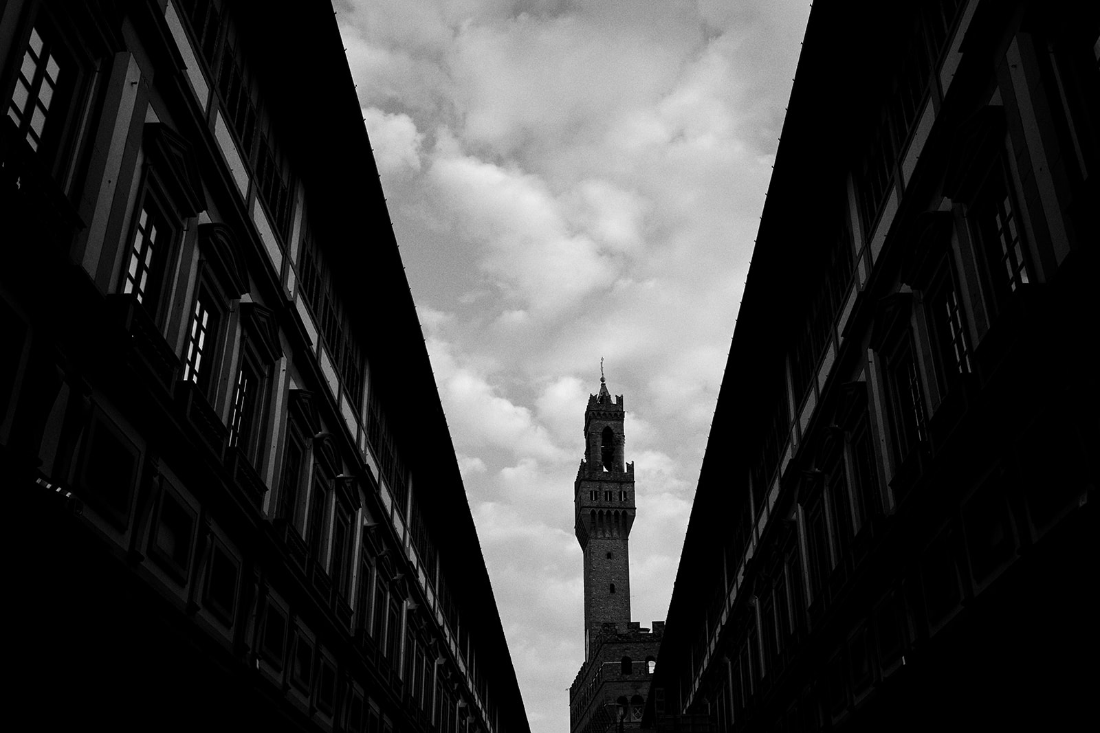 Uffizi colonnade with the Palazzo Vecchio tower at sunrise in Florence