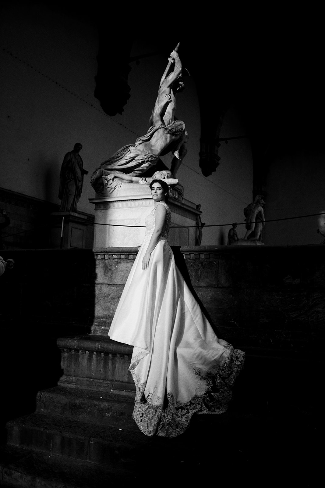 Bride by a statue in Piazza della Signoria at dawn