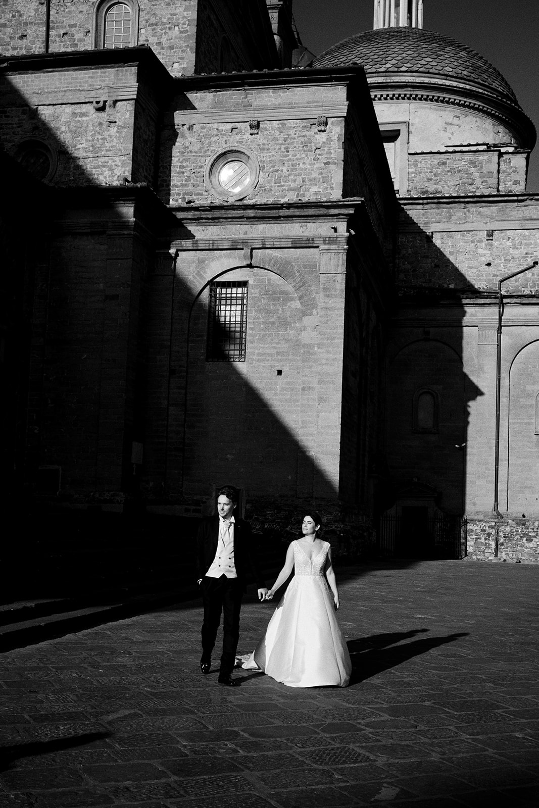 Bride walking toward a Florence church facade at sunrise