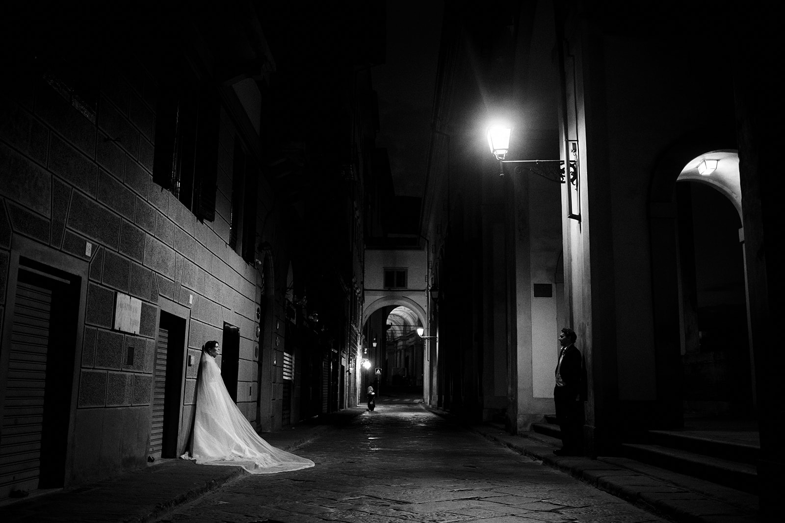Couple beneath a lamp in an empty Florence piazza at blue hour