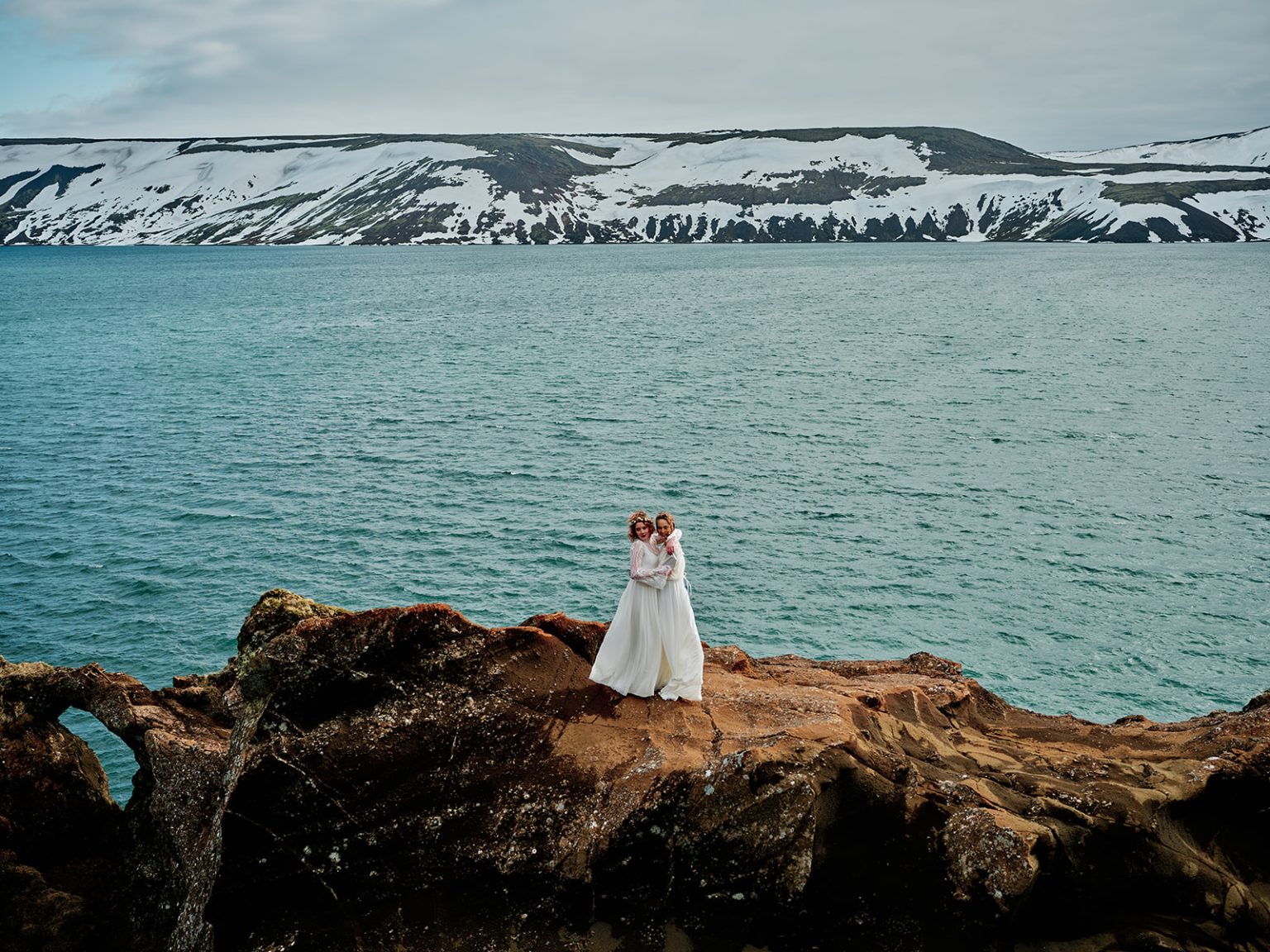 The brides on a snowy ridge above blue water, Reykjanes, Iceland