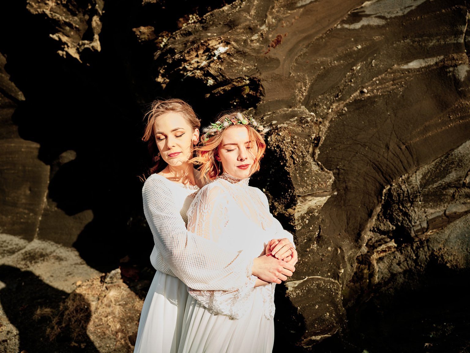 Two brides embracing in the black lava, Reykjanes, Iceland