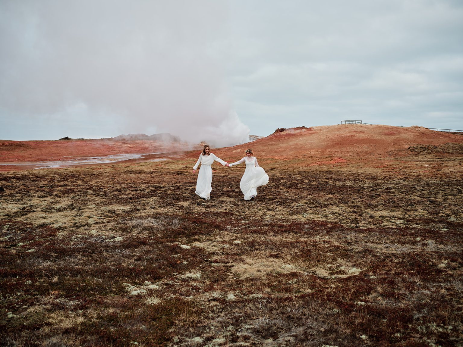 Two brides on the rust-red geothermal field, Reykjanes, Iceland