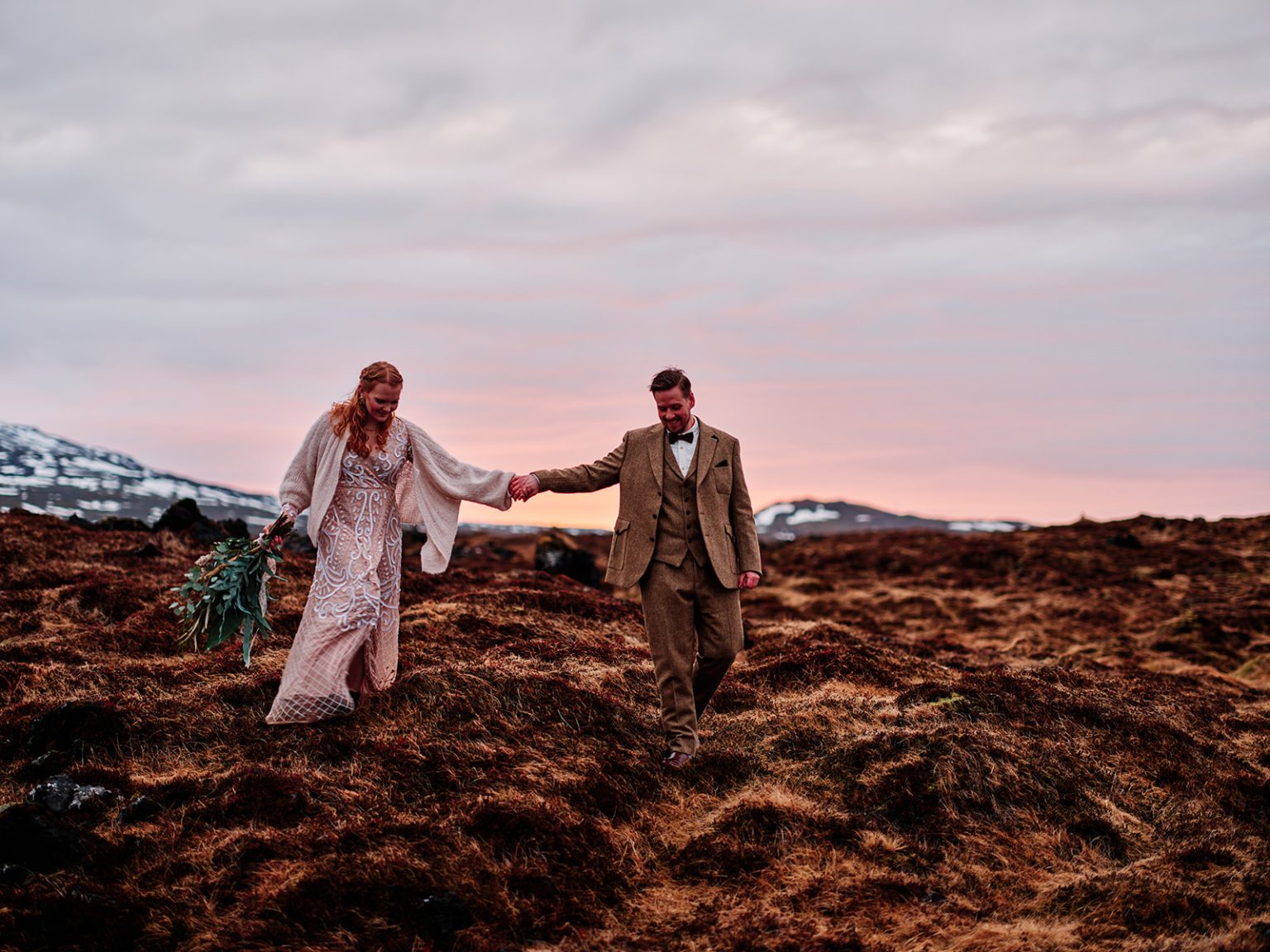 The couple walking hand in hand through the moss at dawn, Snæfellsnes