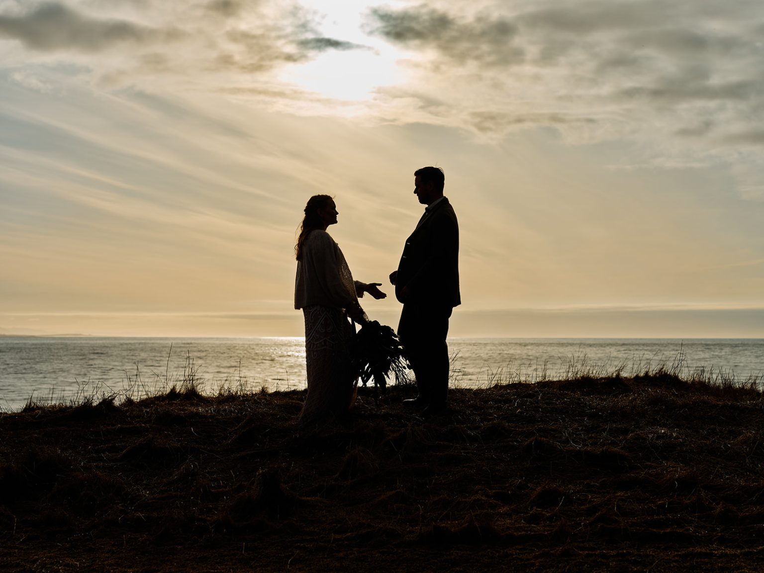 The couple in silhouette at sunrise, a Hótel Búðir elopement