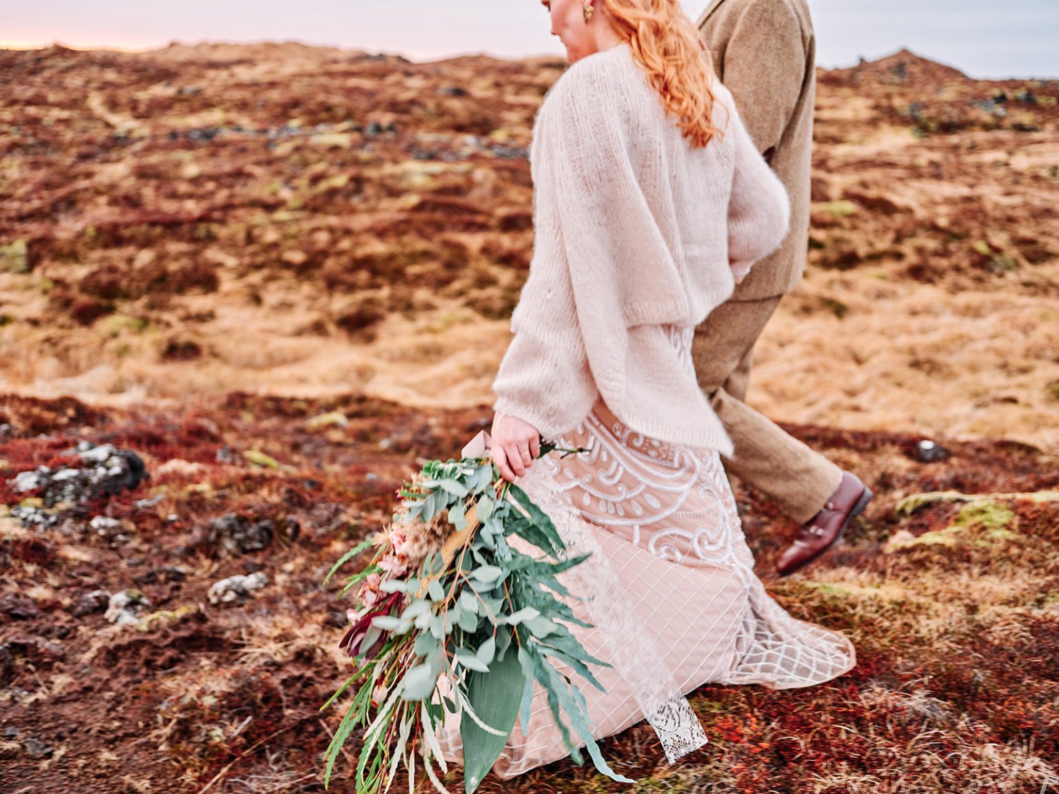 The bride walking with her bouquet at dawn, Búðir, Iceland