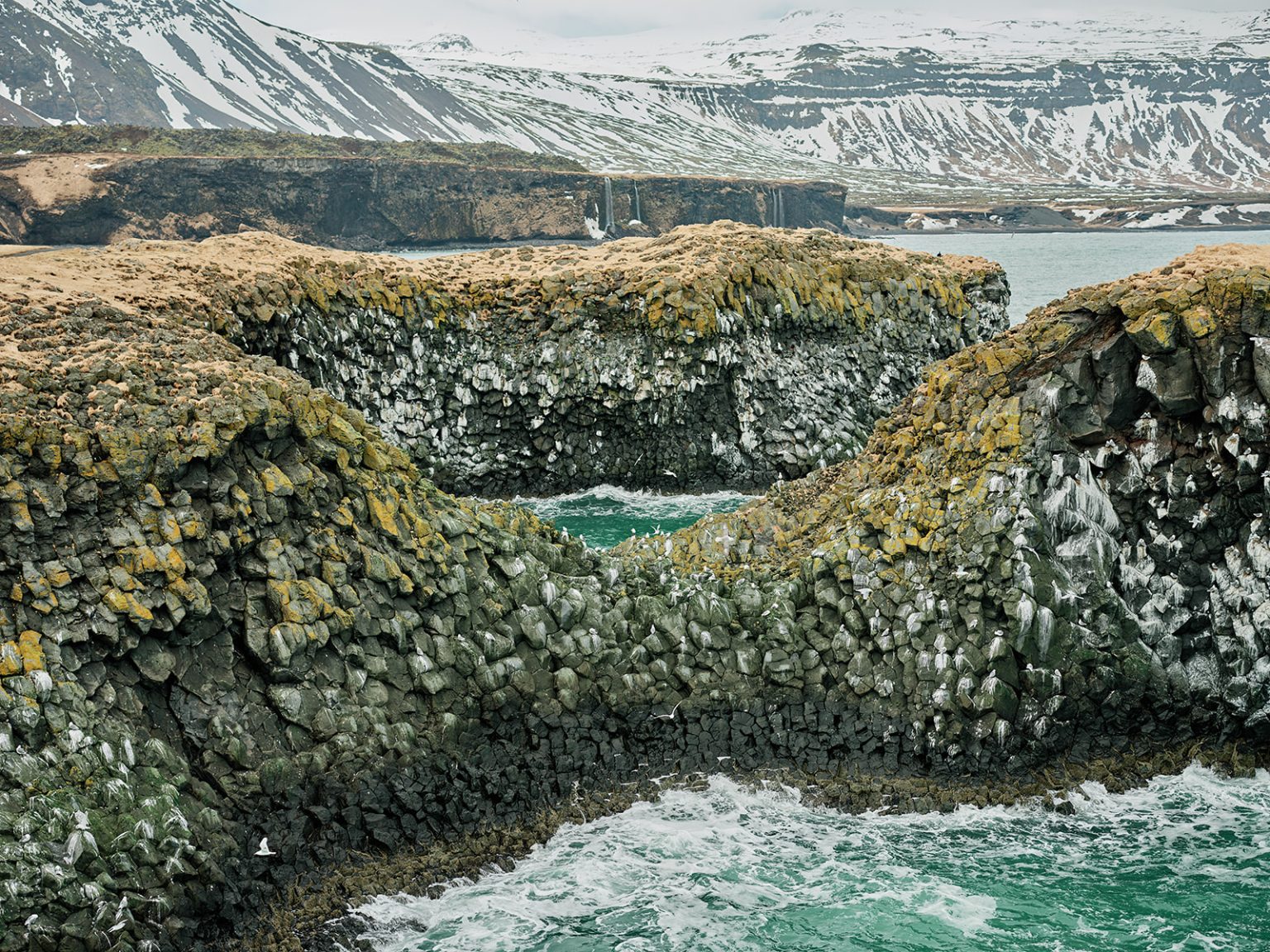 The stone arches of Arnarstapi with the sea through them, Iceland