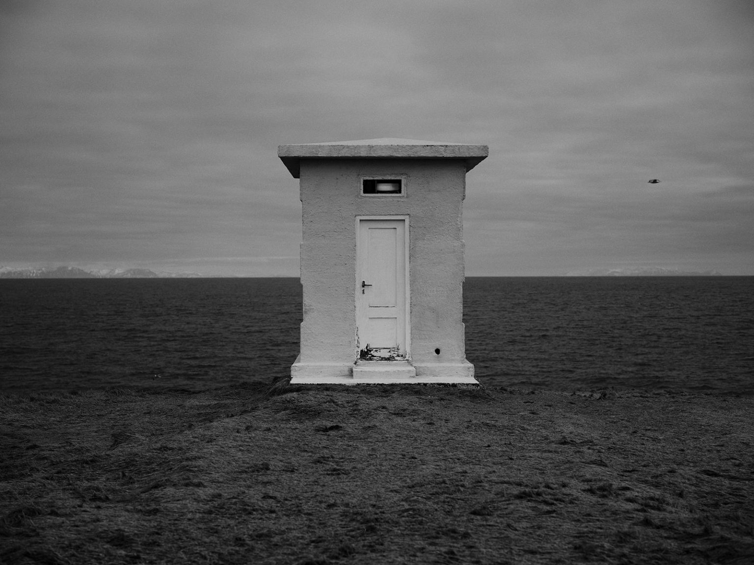 A lone white doorway on the black Snæfellsnes coast, Iceland