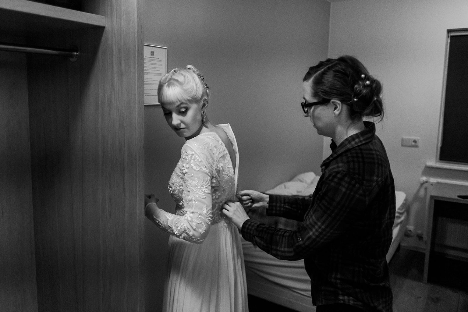 Bride getting ready by lamplight on the morning of an Iceland winter wedding