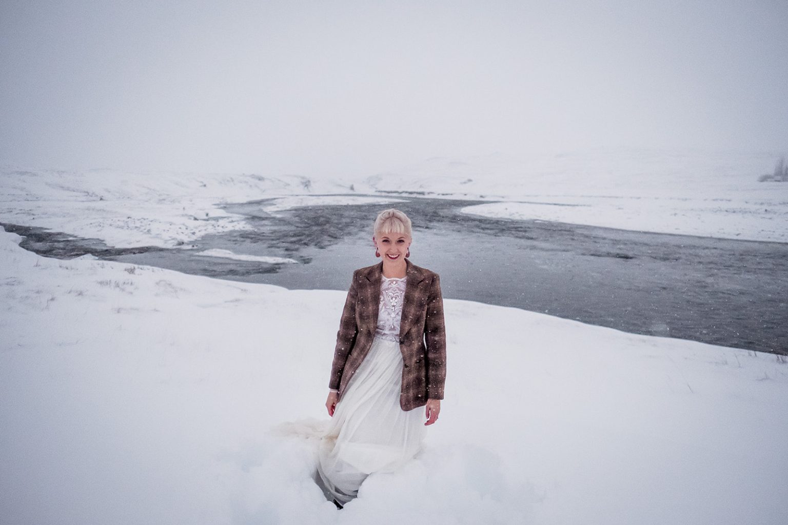 Couple by a frozen river during their Iceland winter wedding