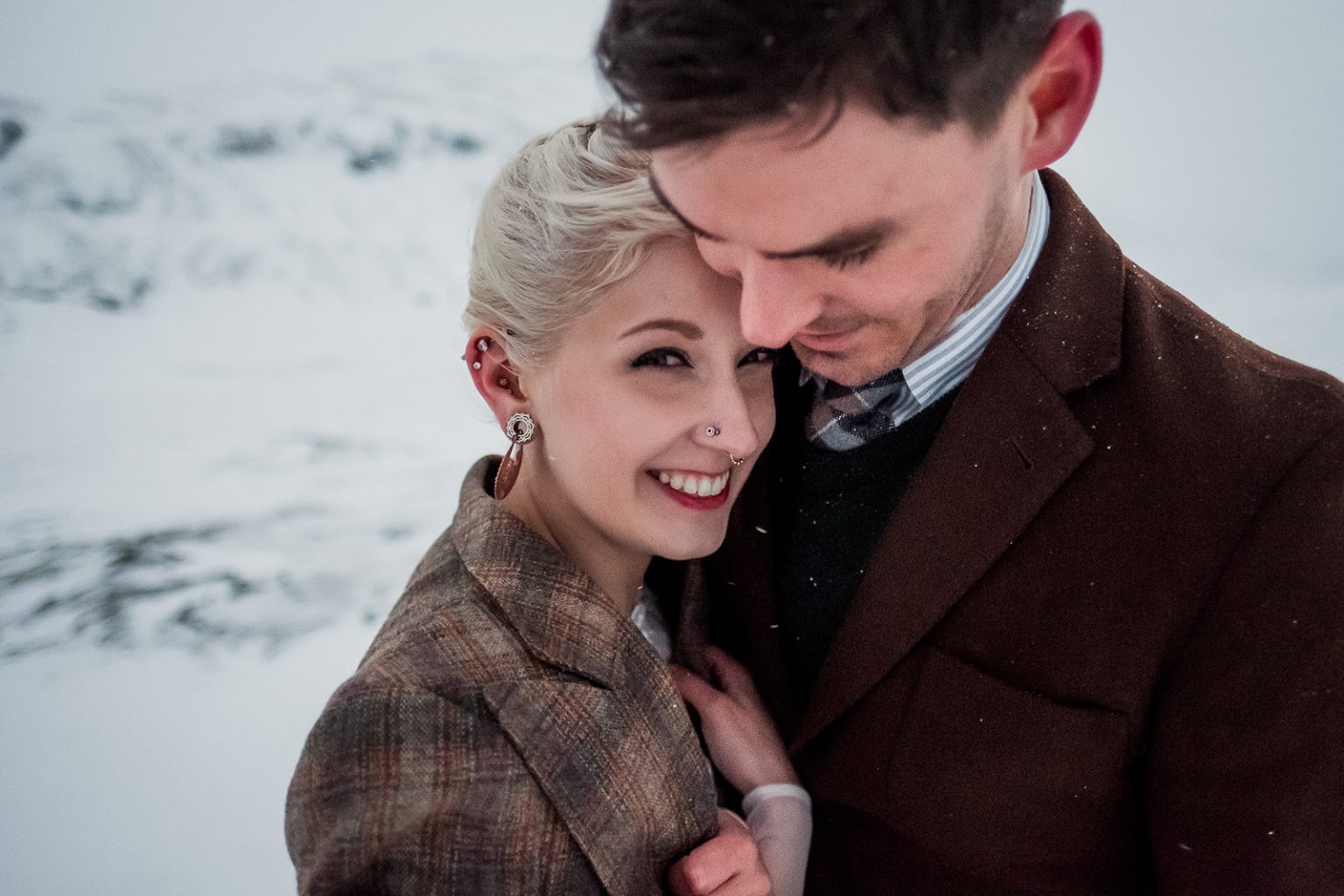 Bride and groom holding each other in the snow in Hvalfjörður