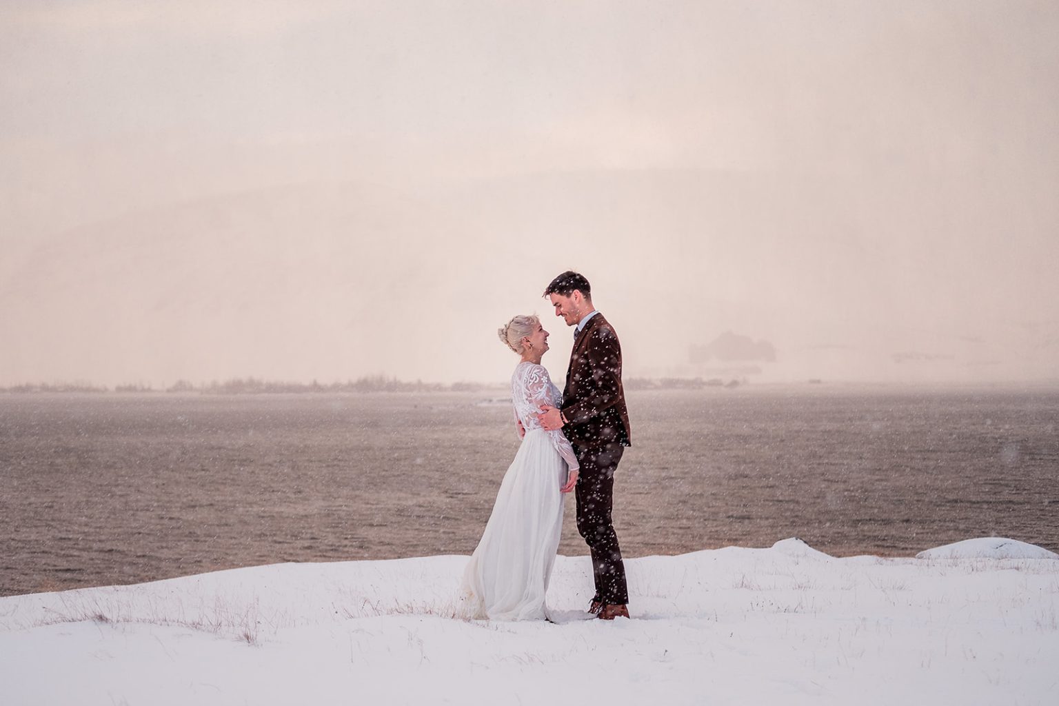 Couple walking the coast in soft winter light in Iceland