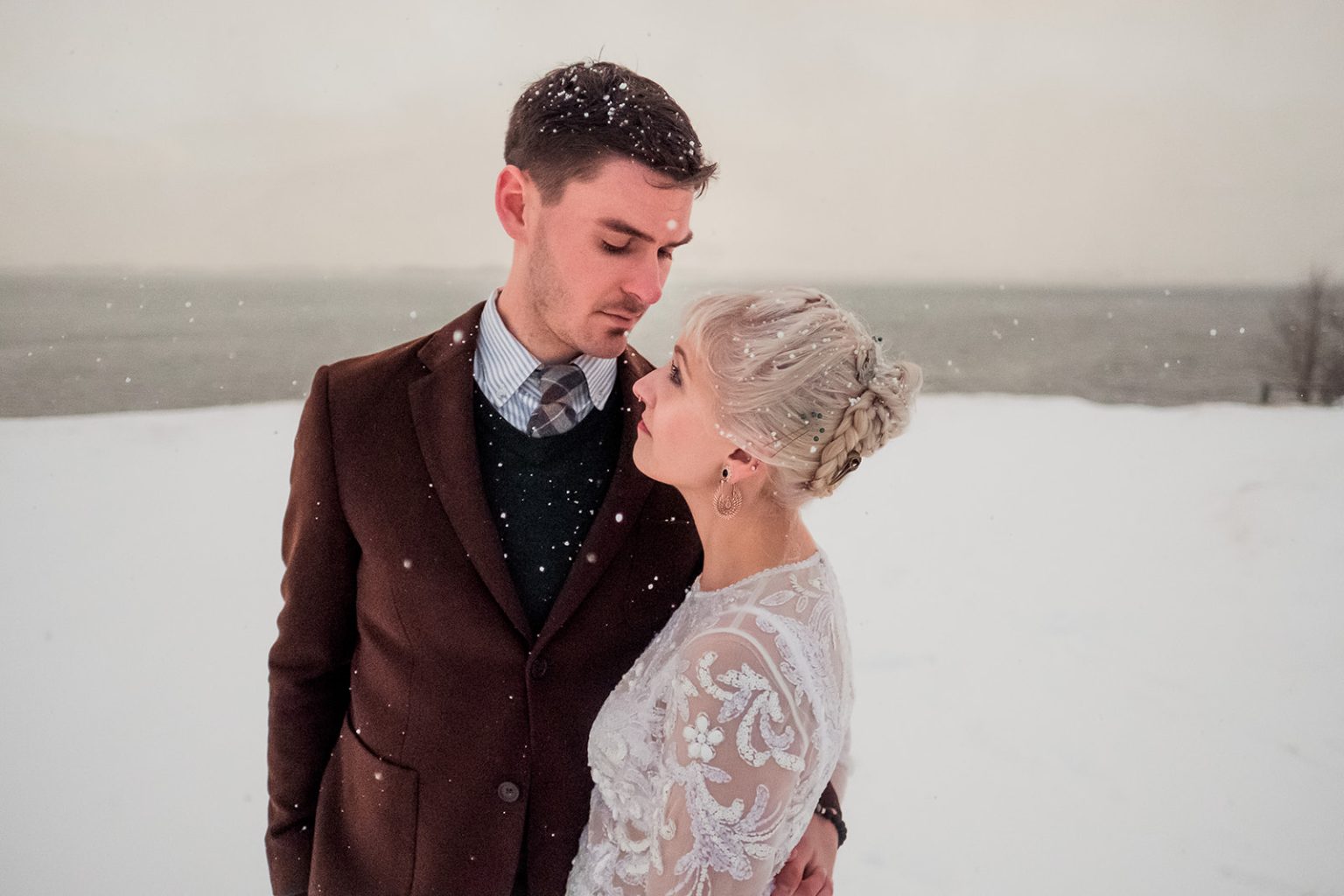 Groom and bride close together on the winter coast