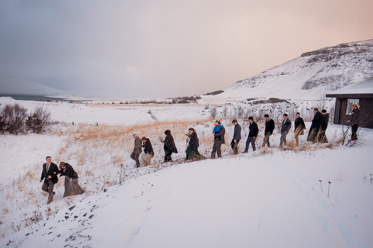 The wedding party walking out across the snow to the ceremony