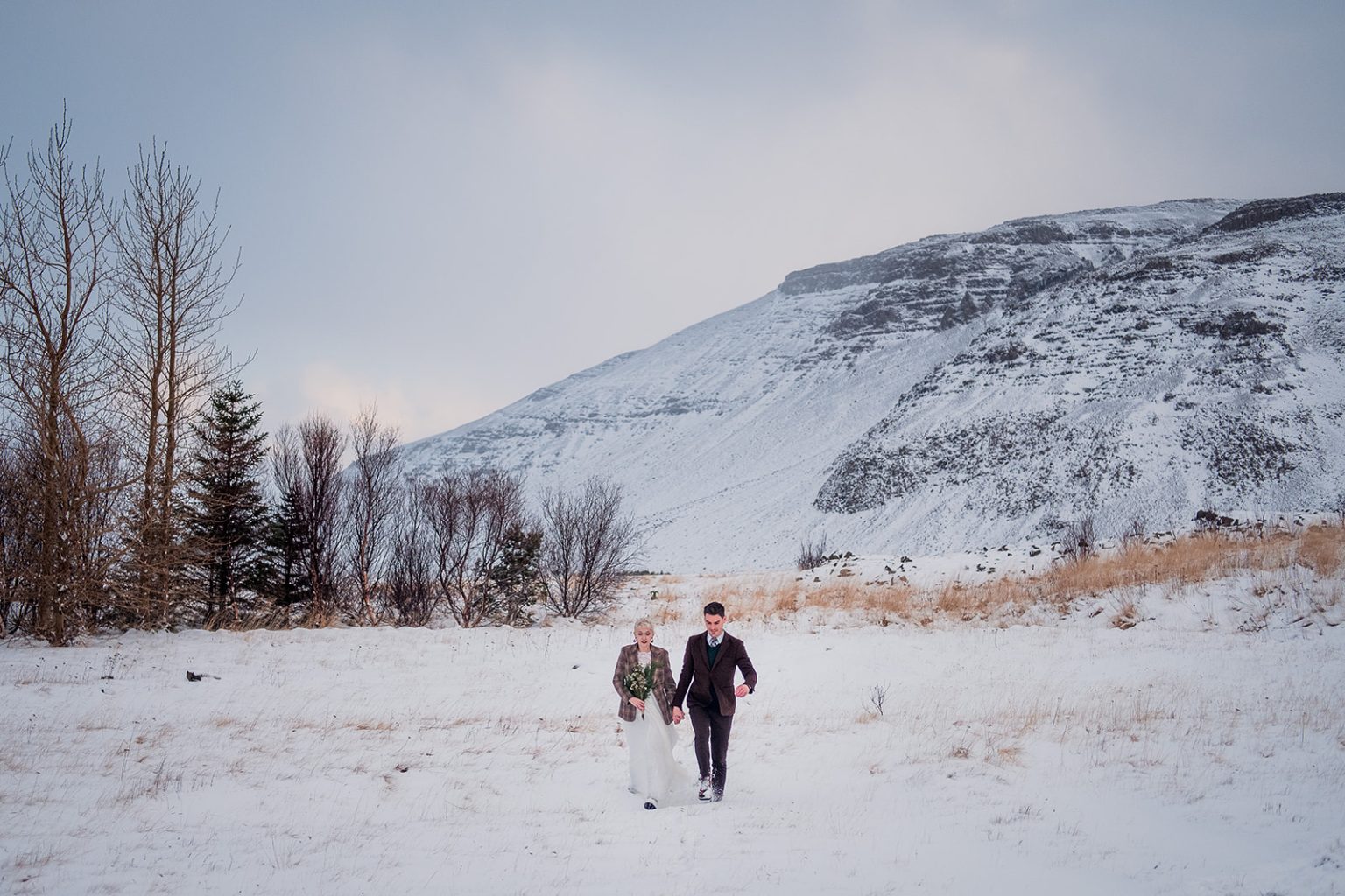 Guests gathering by the water for a winter wedding ceremony in Iceland