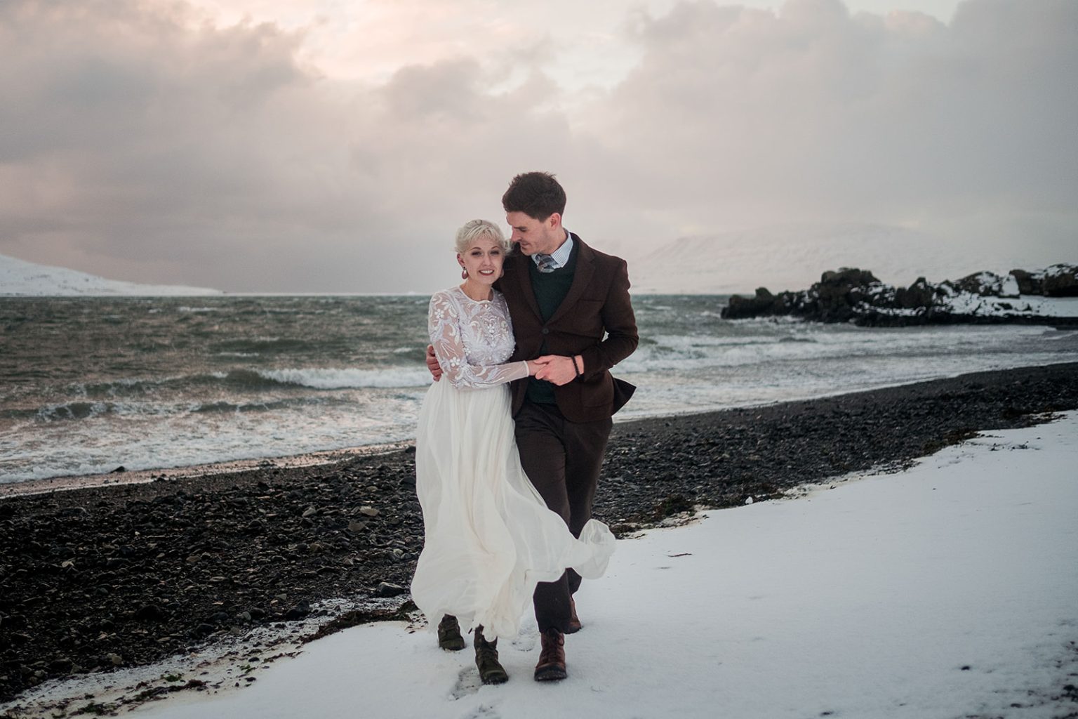 Bride and groom on a black beach along Hvalfjörður
