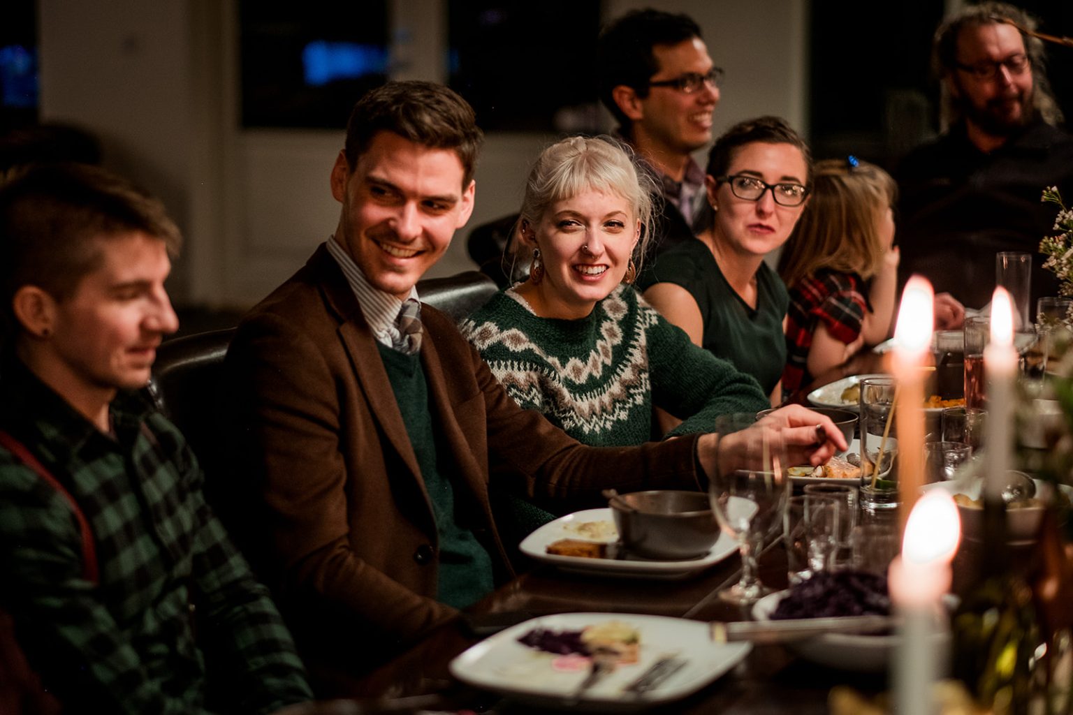 Guests laughing together at the candlelit dinner