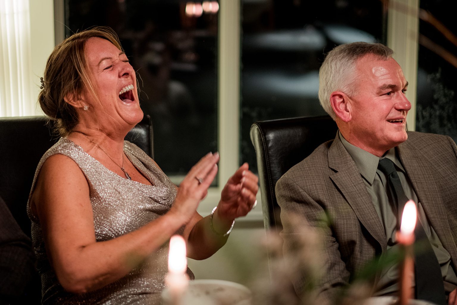 Guests laughing during a candlelit wedding dinner in Iceland