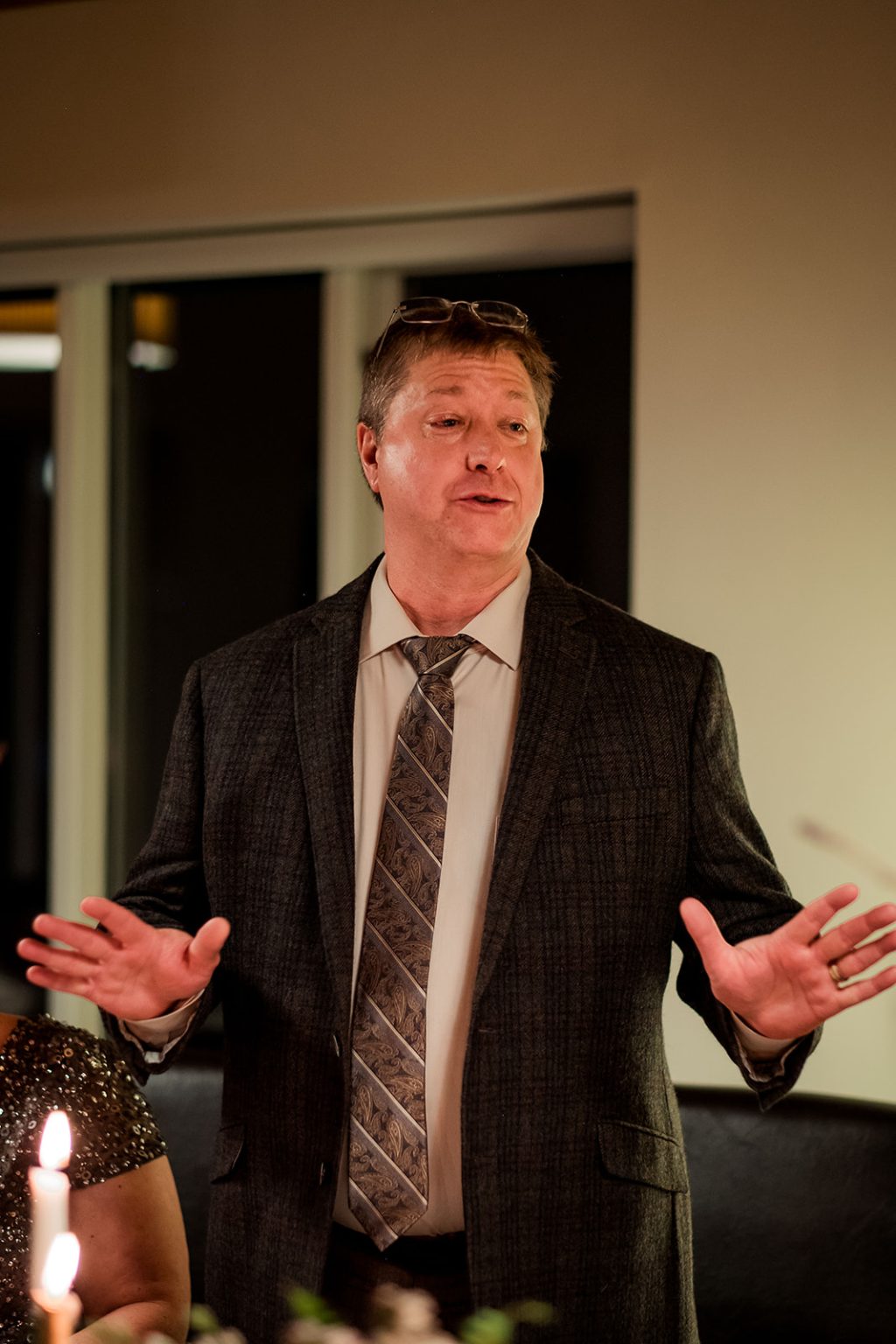 A guest giving a speech at the candlelit wedding dinner