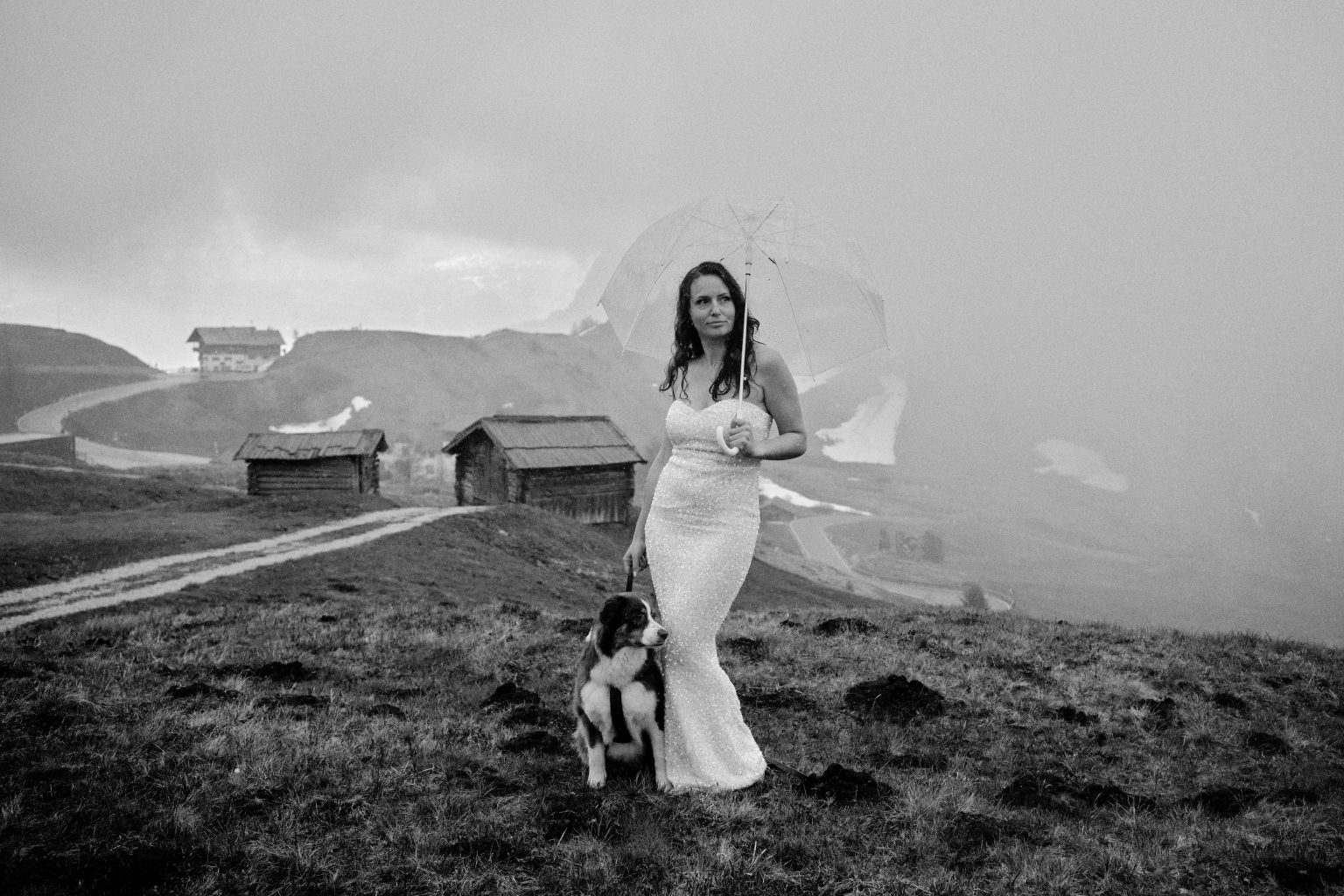Bride by an alpine hut in the mist, Dolomites