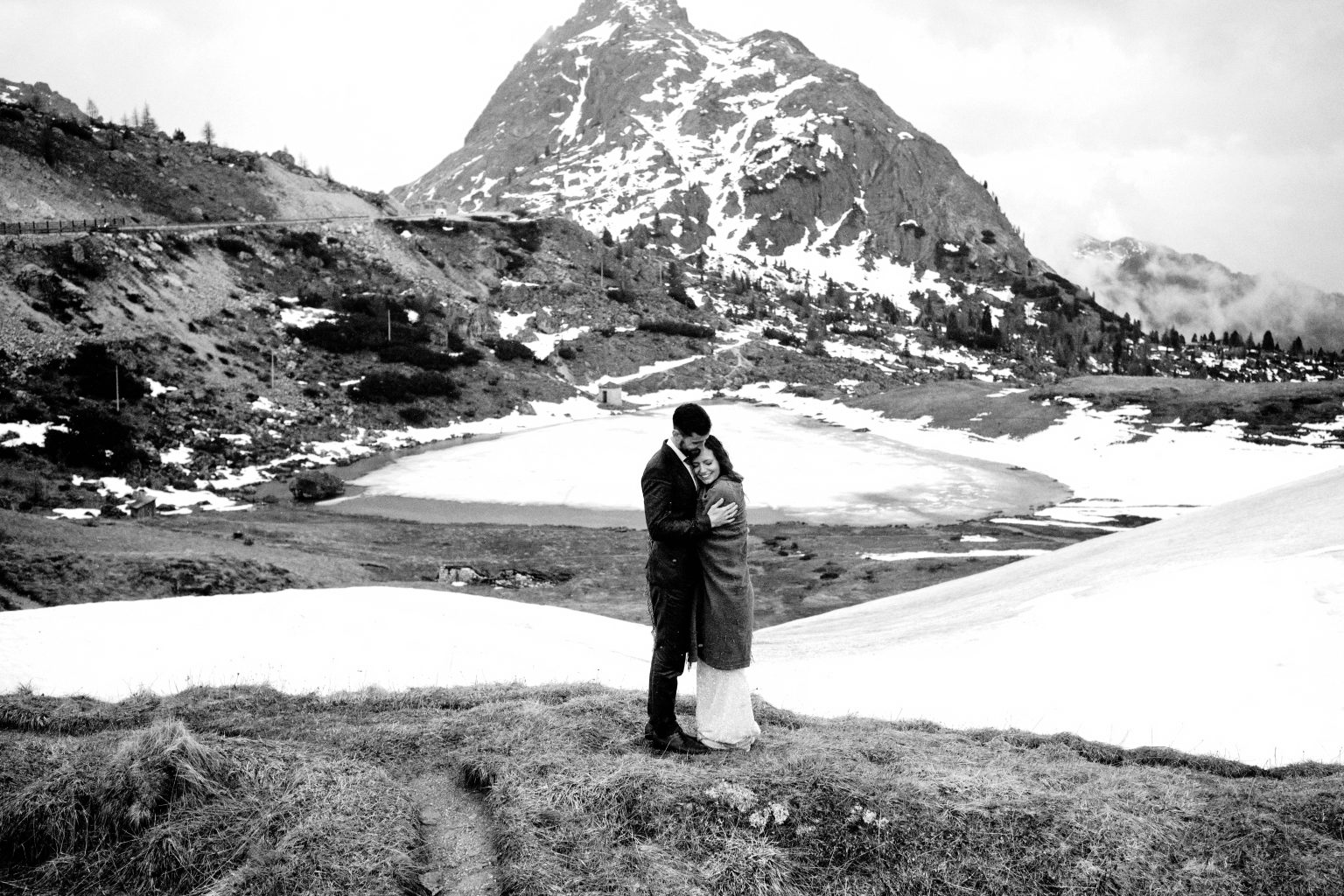 Couple by an alpine tarn below the peaks, Passo Gardena
