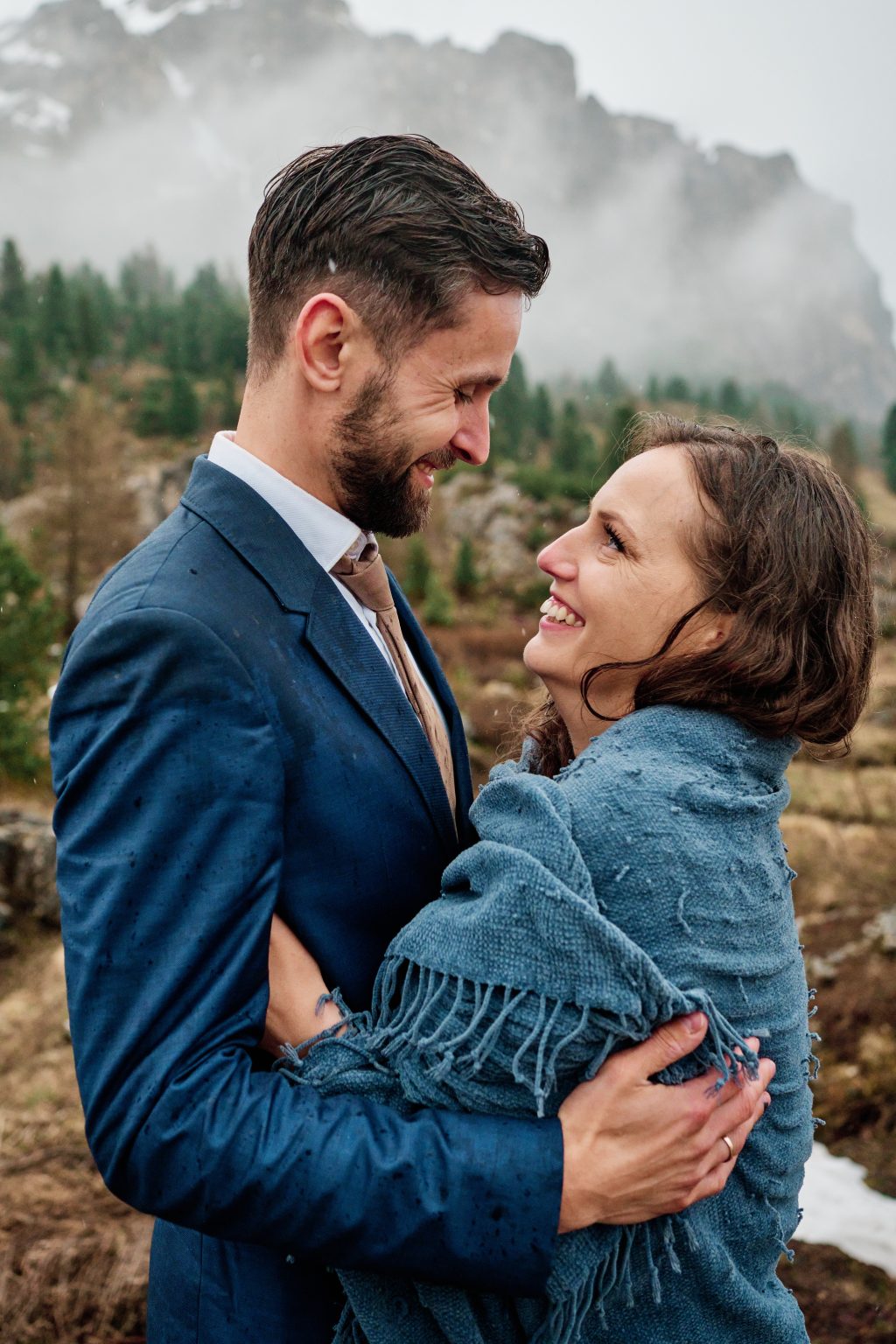 Simona and Marius laughing in the rain at Passo Gardena