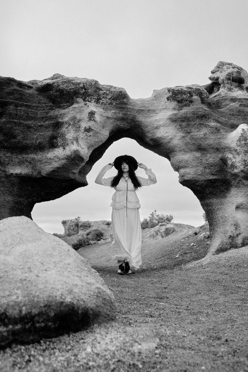 Bride beneath a natural rock arch, black and white, Lanzarote