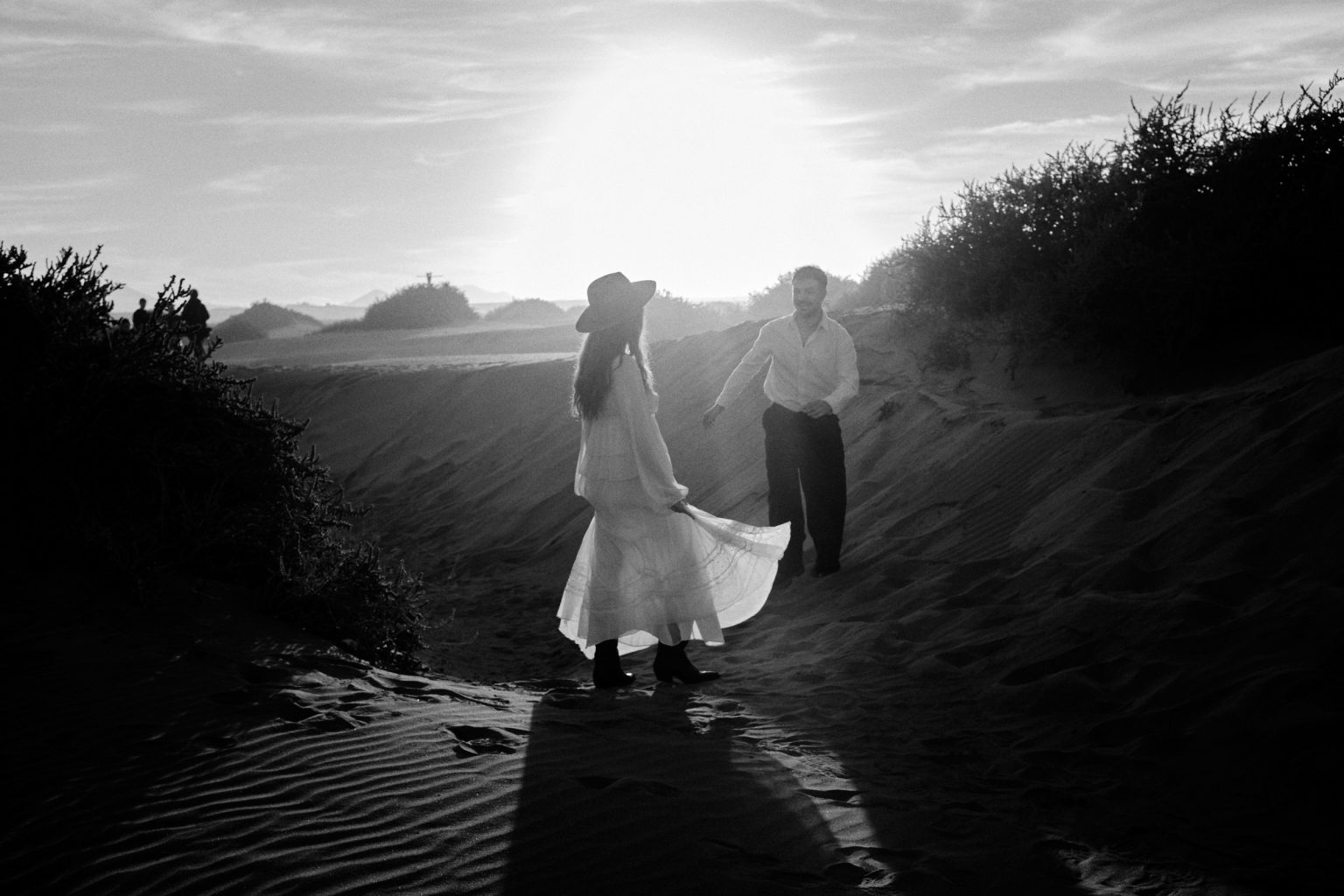 Couple walking down through the dunes, black and white, Lanzarote