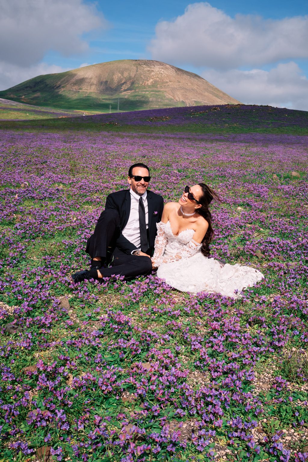 Juan and Laura sitting in the wildflowers, Lanzarote wedding