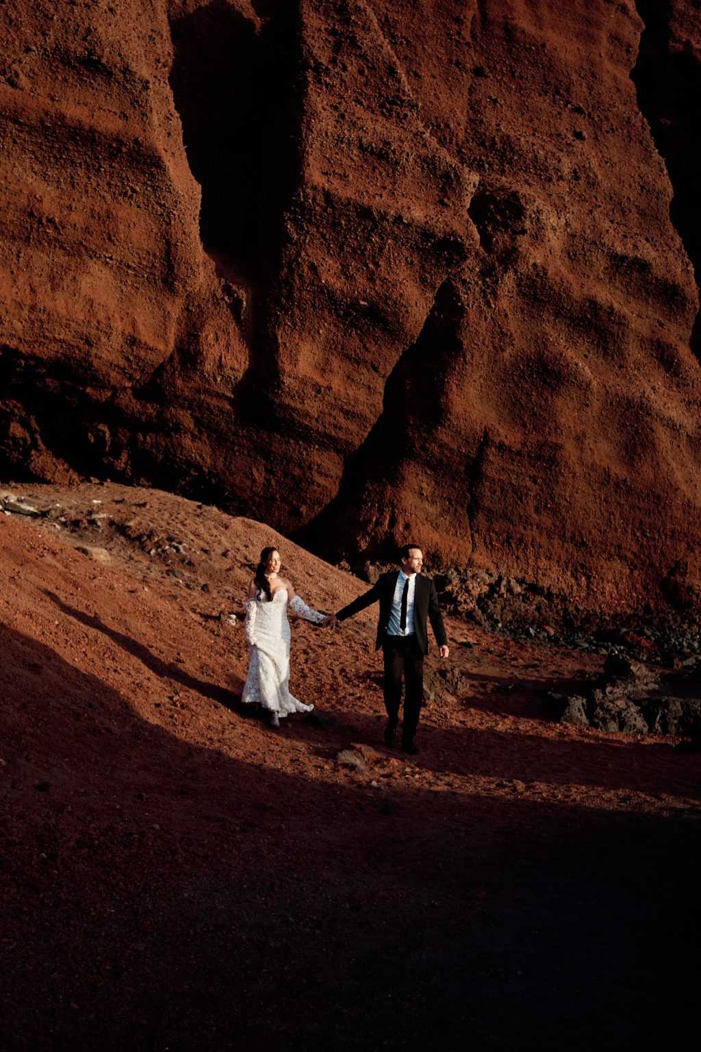 Juan and Laura dwarfed by the red cliffs of Lanzarote