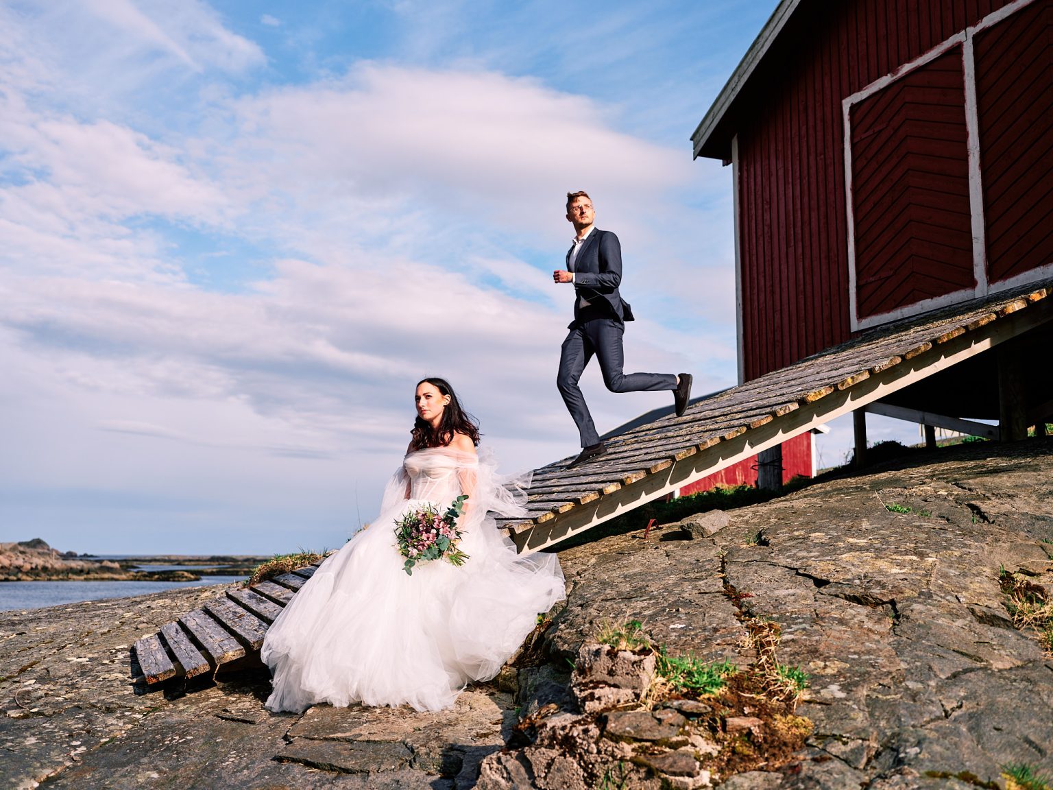 Sophie and Johan by the red rorbu cabins of a Lofoten fishing village