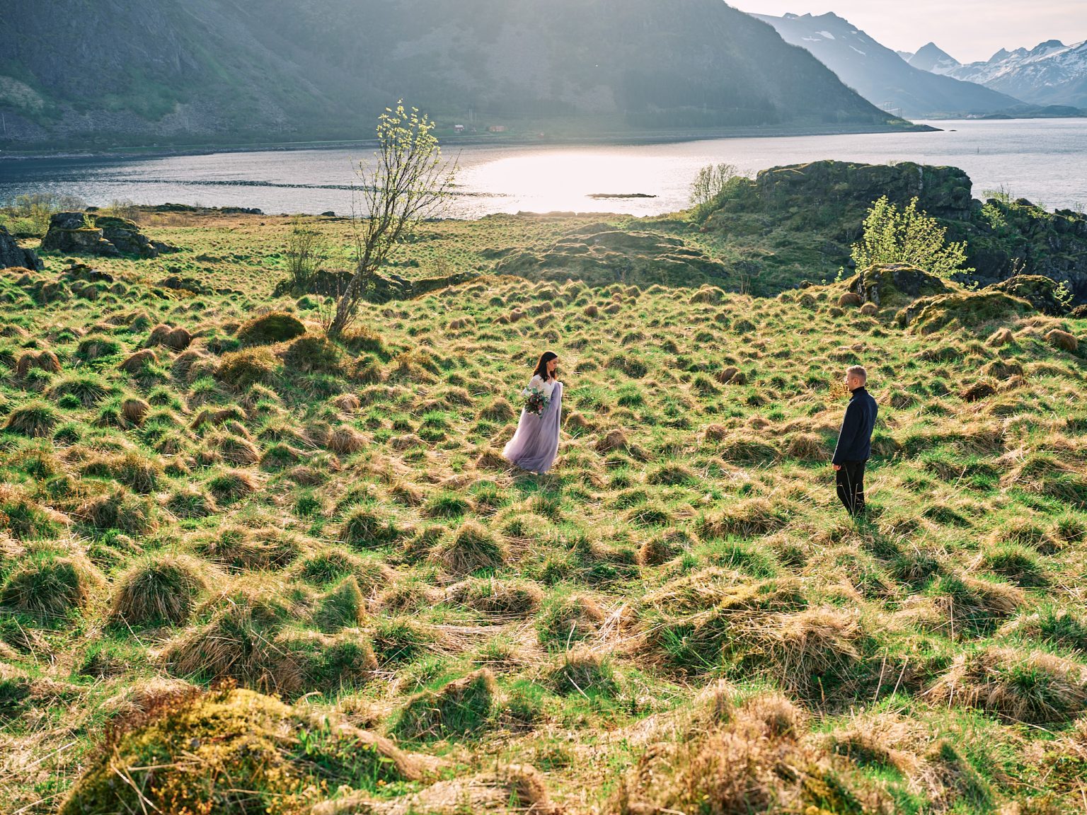 The bride walking a green meadow above the Lofoten sea
