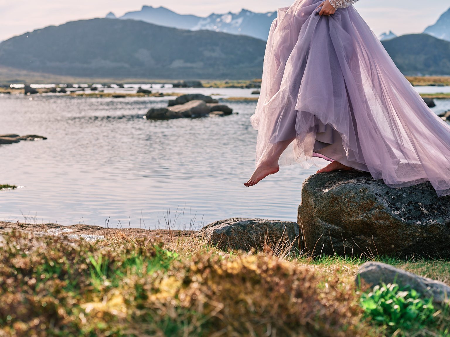 The bride's dress on the rocks by a Lofoten fjord