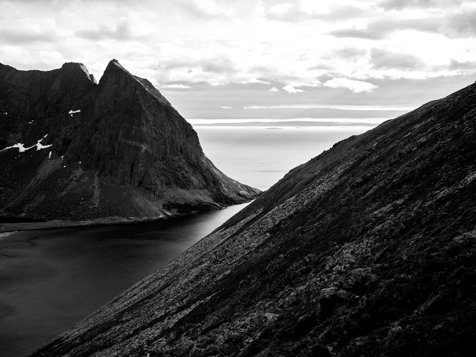 Dark Lofoten peaks dropping to the sea, black and white