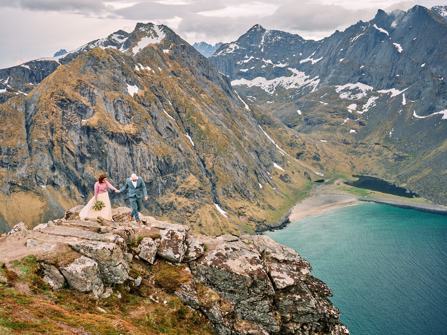 The couple walking the ridge on Ryten, Lofoten peaks behind
