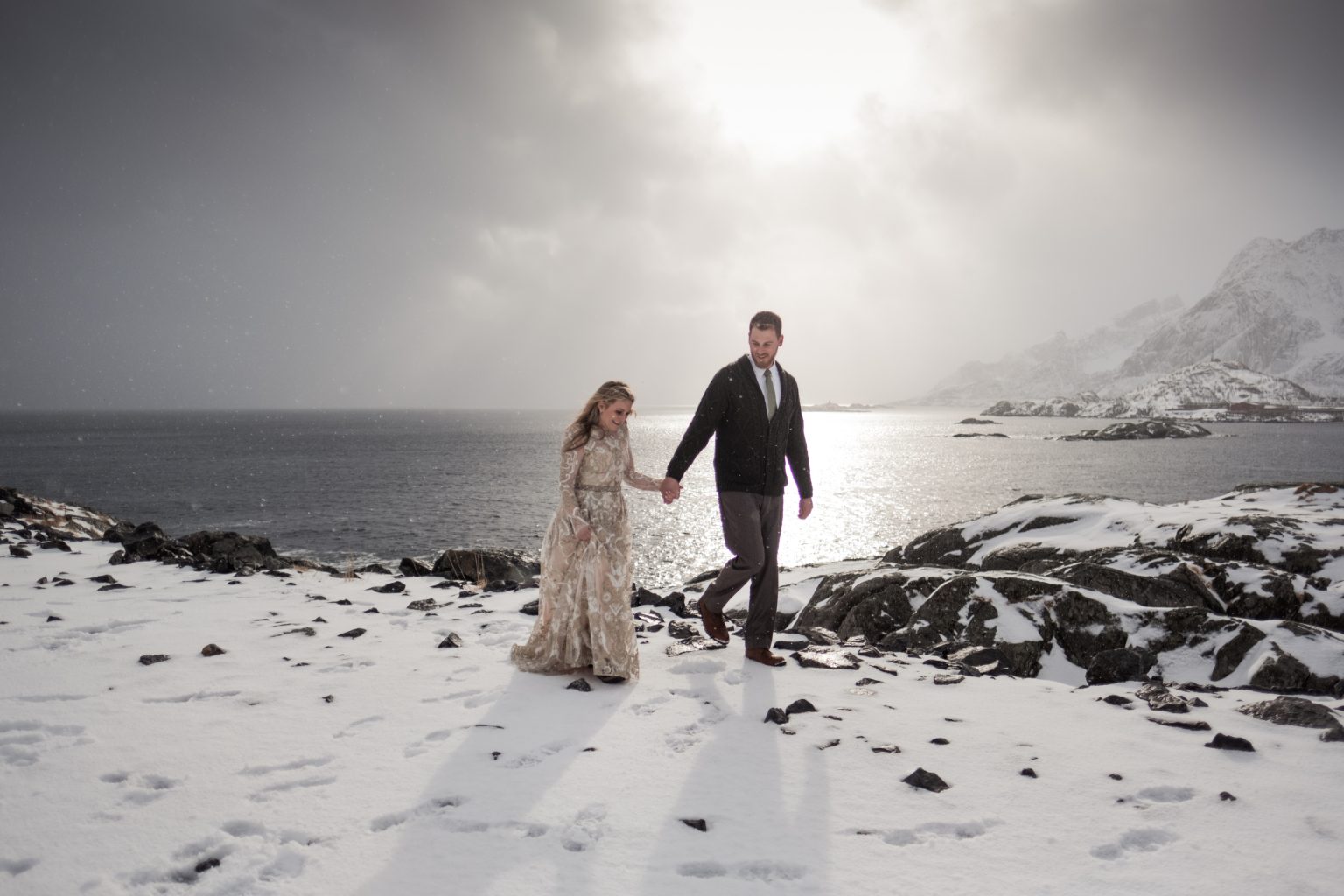 The couple walking under storm light, Lofoten in winter