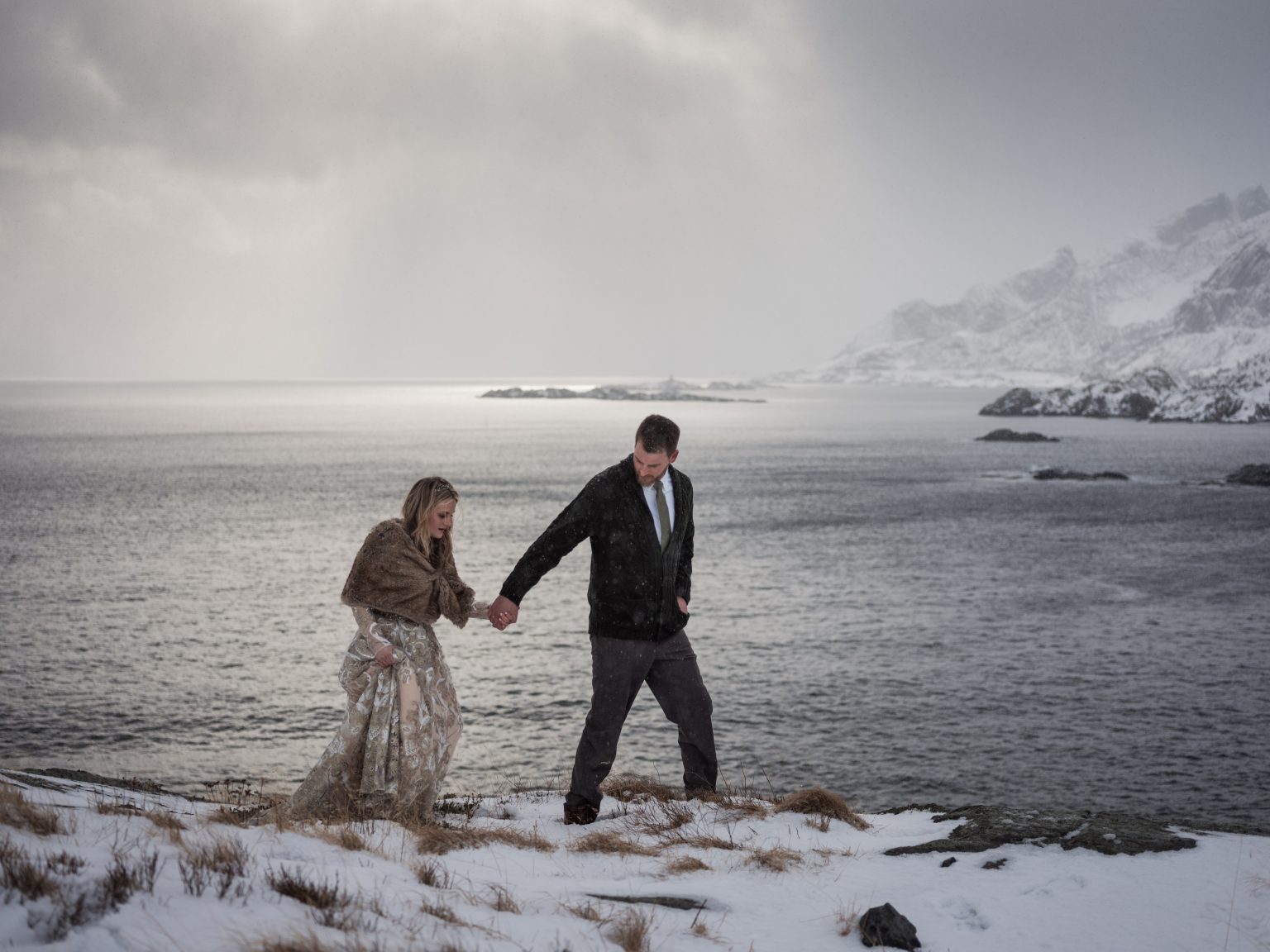 Walking hand in hand across the snow, Lofoten, Norway
