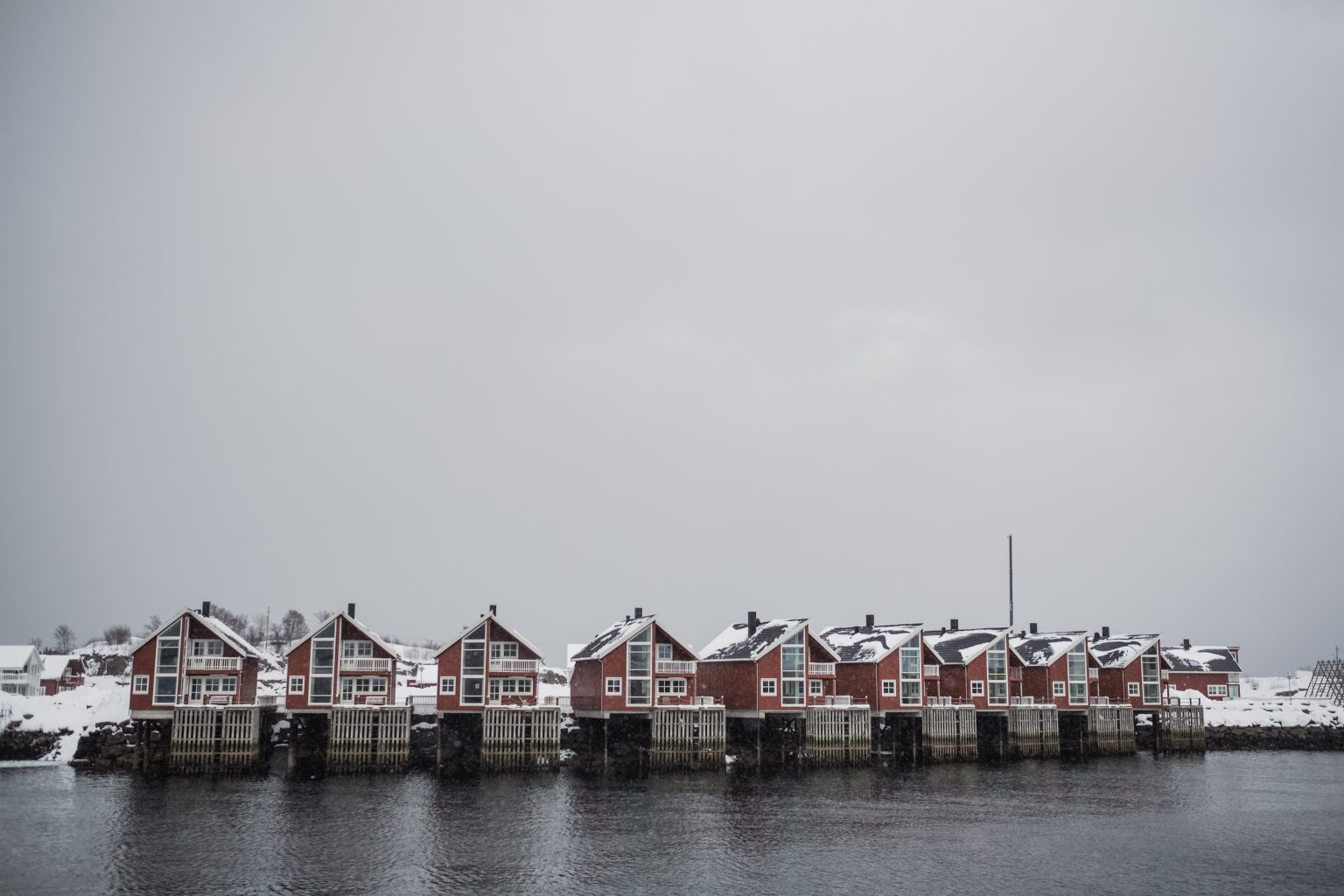 Red rorbuer cabins by frozen water, a Lofoten winter elopement