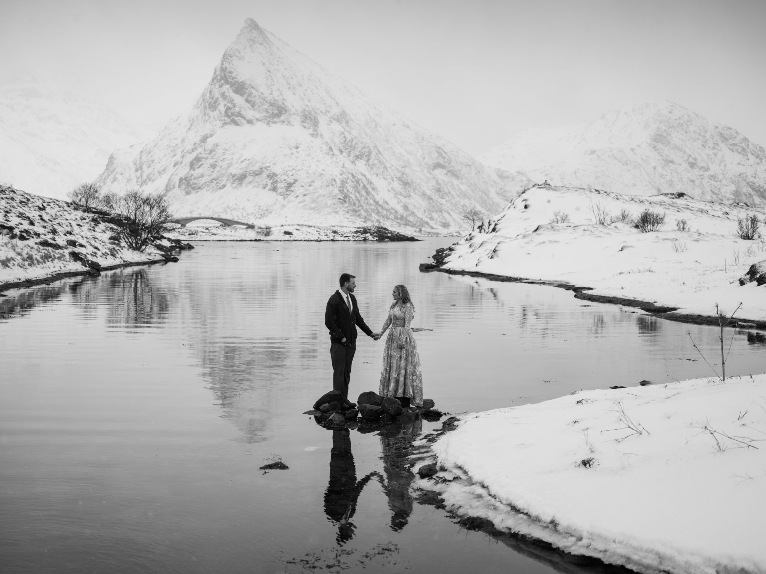 The couple on the ice with the peaks mirrored, Lofoten in winter