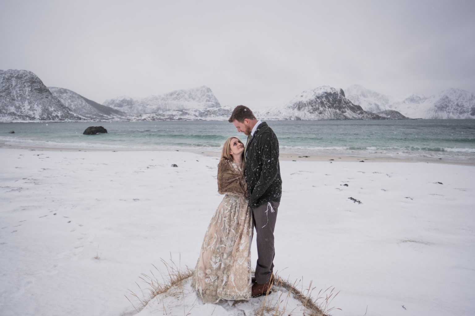 Embracing below the snowy mountains, a Lofoten winter elopement